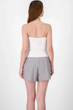 Top formal con bolsas y accentos de botones